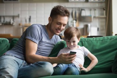 Telefon komik video izlerken çocuk oğlu ile gülümseyen baba