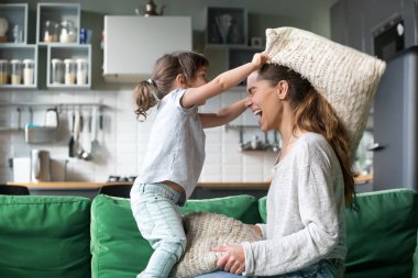 Anne ve çocuk kızı birlikte oynayan yastık kavga