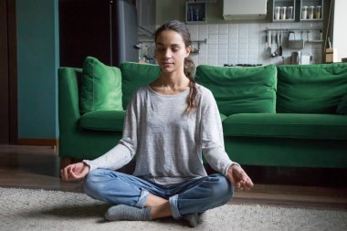 Nilüfer çiçeğinde oturan sakin kadın evde meditasyon yapıyor.