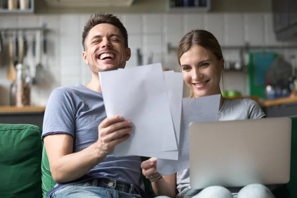 Gelukkige paar lachen met plezier met documenten en laptop — Stockfoto