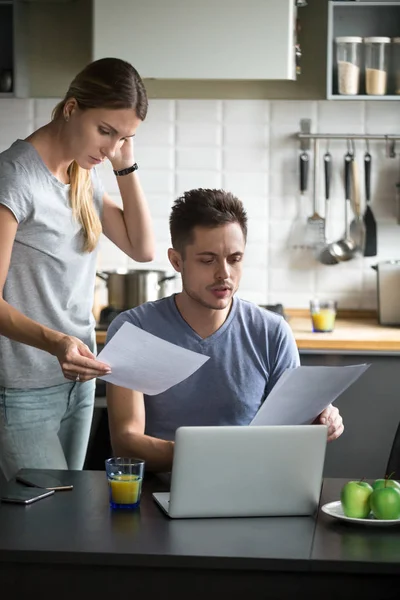 Confundida pareja joven preocupada por comprobar las cuentas domésticas que tienen aleta — Foto de Stock