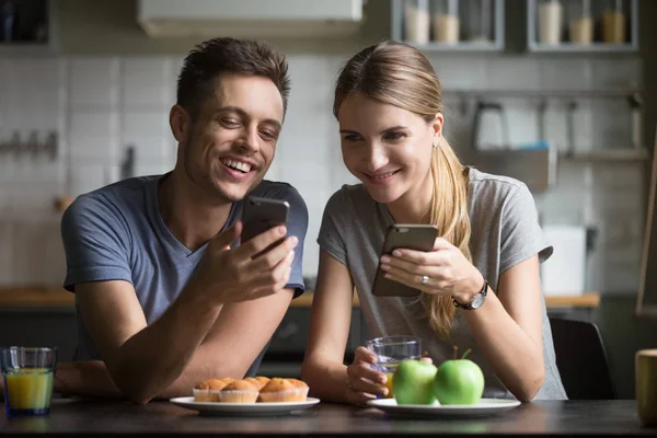 Sonriendo feliz pareja riendo usando aplicaciones de teléfonos inteligentes que tienen brea — Foto de Stock