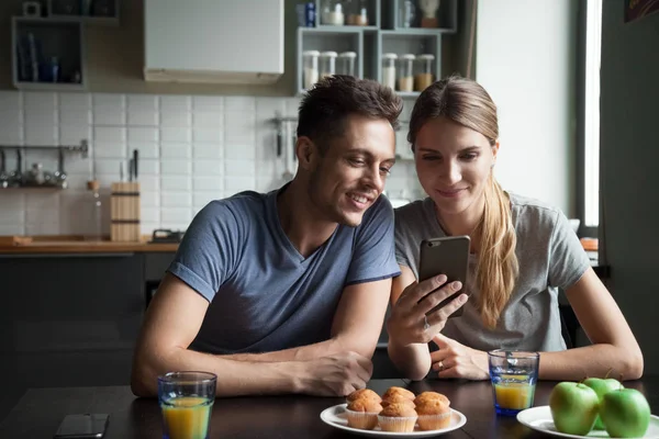 Sonriente joven pareja viendo vídeo en línea utilizando el teléfono inteligente havi — Foto de Stock