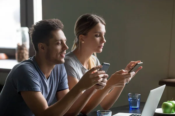 Молода пара одержима використанням телефонних додатків, що ігнорують один одного — стокове фото