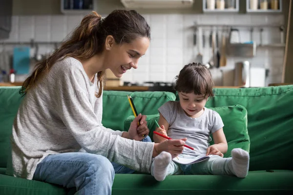 Maman et enfant fille dessin avec crayons de couleur à la maison — Photo