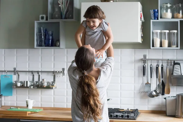 Anne kaldırma çocuk kız mutfakta, arkadan görünüş — Stok fotoğraf