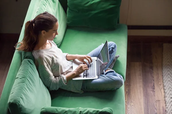 Mulher milenar verificando notícias, trabalhando on-line no laptop em casa — Fotografia de Stock