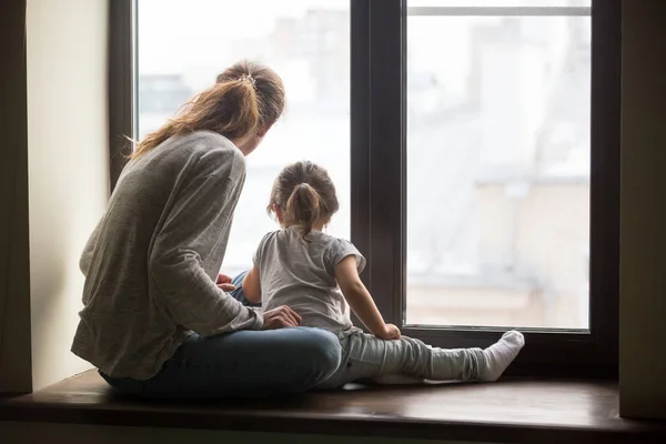 Vue arrière du gamin fille et mère assis sur le seuil — Photo