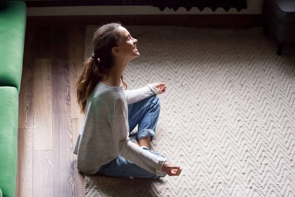 Sorrindo mulher se divertindo aprendendo exercícios de ioga em casa — Fotografia de Stock