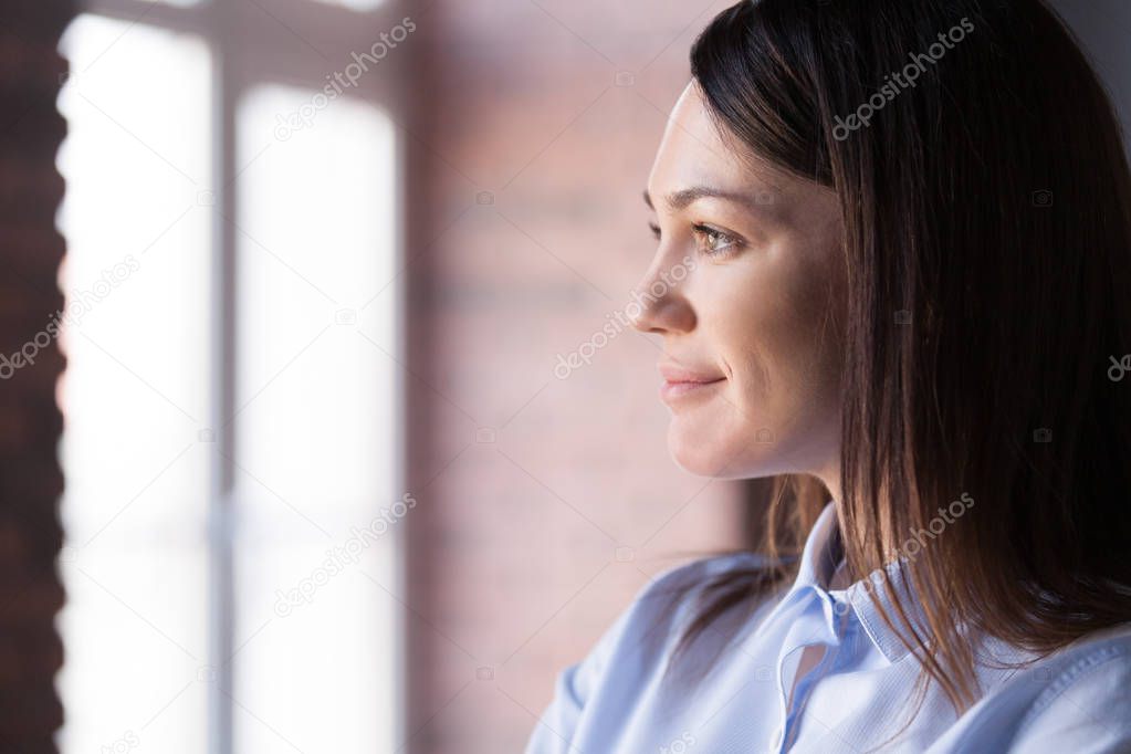 Close up of smiling female looking in distance dreaming 