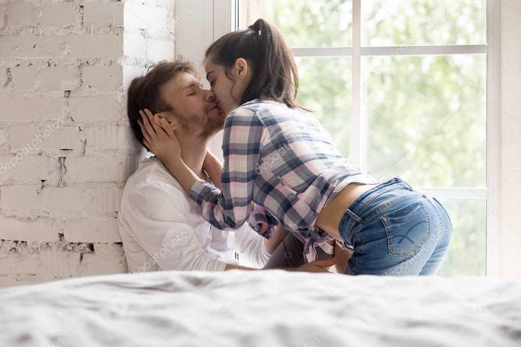 Romantic couple kissing enjoying sensual foreplay at home