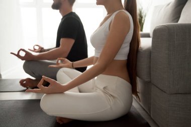 Close up of fit couple meditating practicing yoga at home clipart