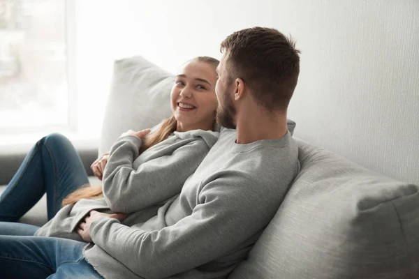 Loving millennial couple hugging relaxing on cozy couch — Stock Photo, Image