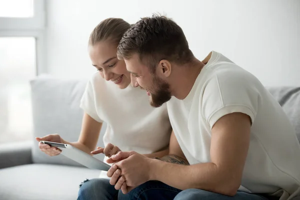 Excited couple play new game on tablet — Stock Photo, Image