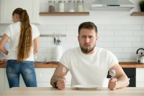 Dissatisfied man waiting for dinner cooked by wife — Stock Photo, Image