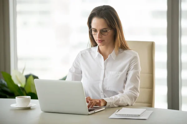 Mujer de negocios seria usando software de negocios de computadoras sentado un — Foto de Stock