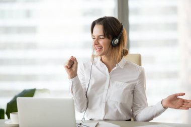 Excited happy businesswoman listening to music in headphones at  clipart