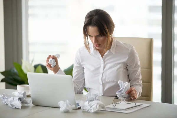Stresovaní podnikatelka drží zmačkaný papír dopisuje u — Stock fotografie