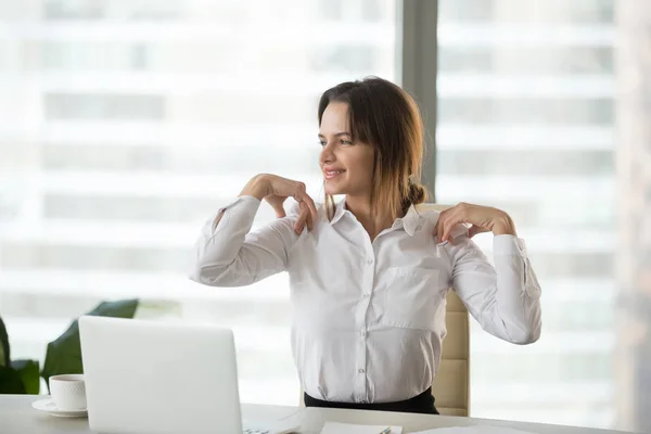 Mujer de negocios sonriente haciendo ejercicios de oficina para aliviar el hombro — Foto de Stock