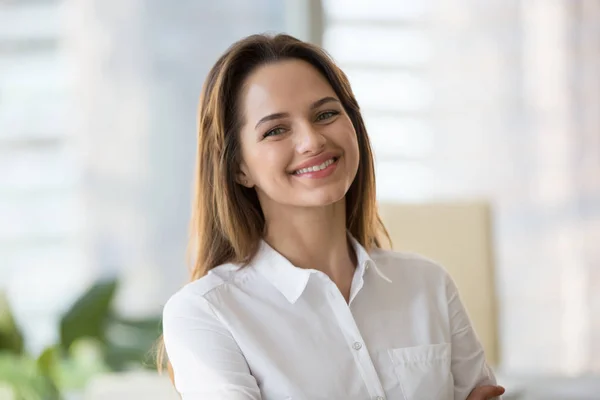 Glücklich lächelnde Millennial-Geschäftsfrau blickt in offi in die Kamera — Stockfoto