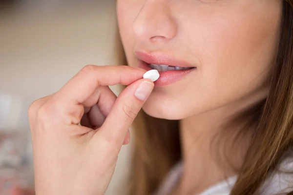 Close up view of woman taking pill to relieve pain — Stock Photo, Image