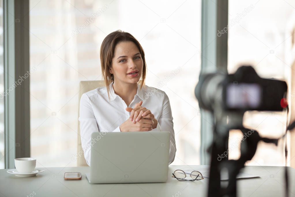 Young businesswoman vlogger recording vlog talking to camera in 