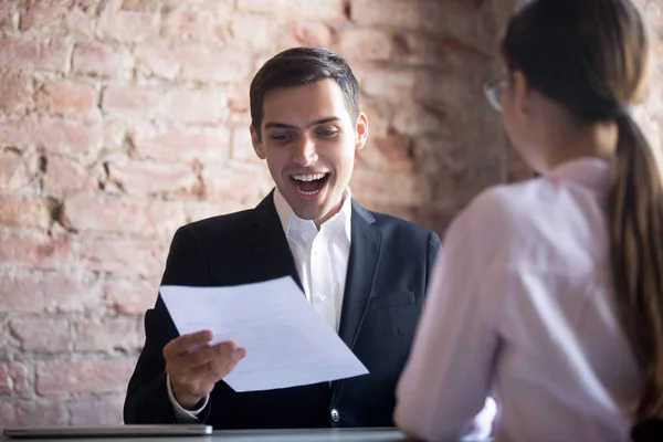 Happy worker with paper at workplace in hand — Stock Photo, Image