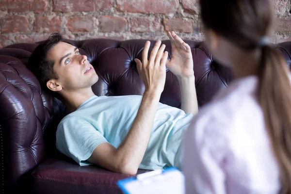 Man lying and talking with woman, at the psychotherapist — Stock Photo, Image