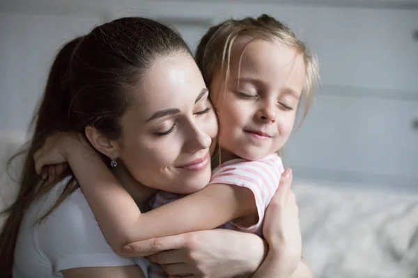 Närbild på ung mamma kramar söta lilla dotter — Stockfoto
