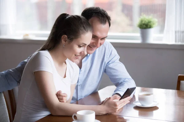 Smiling couple shopping online on smartphone having morning coff — Stock Photo, Image