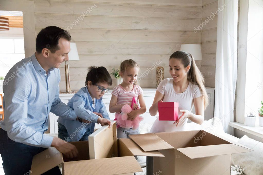 Happy family unpack cardboard boxes moving to new home