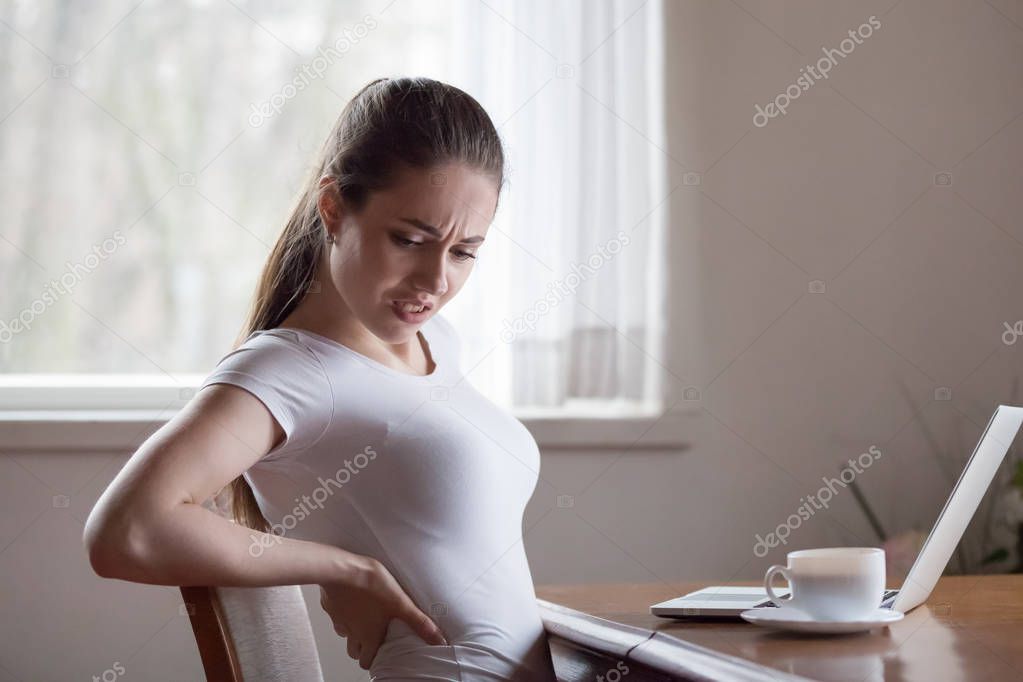 Tired woman suffering from back pain or discomfort