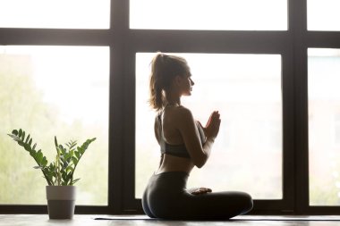 Yarım Lotus poz oturan genç sportif kadın