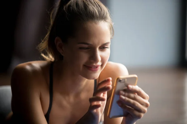 Yoga uygulamak sonra cep telefonu kullanan genç sportif kadın — Stok fotoğraf