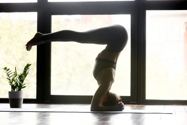 Mujer yogui joven haciendo ejercicio de cabeza de yoga — Foto de Stock