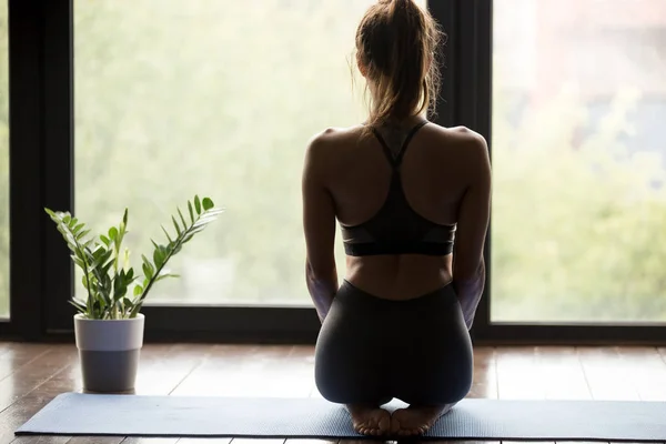 Young yogi girl doing yoga vajrasana, back view — Stock Photo, Image