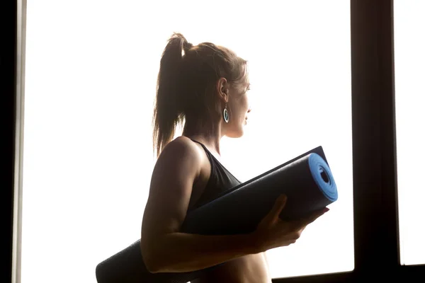 Sporty woman holding blue yoga mat, healthy lifestyle concept — Stock Photo, Image