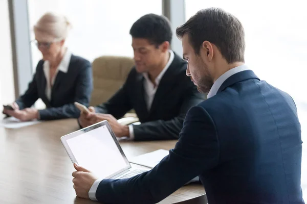 Tres colegas diversos sentados en el escritorio trabajan juntos en línea — Foto de Stock