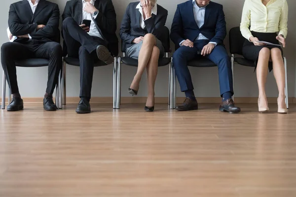 Businesspeople legs sitting in chair in queue wait job interview — Stock Photo, Image