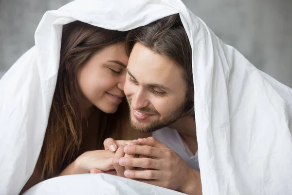 Zartes Paar entspannt sich am Sonntagmorgen unter einer Decke im Bett — Stockfoto