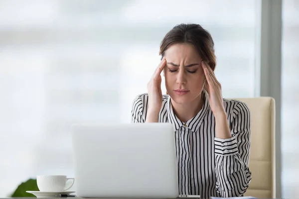 Mujer de negocios cansada que sufre de dolor de cabeza en el cargo — Foto de Stock