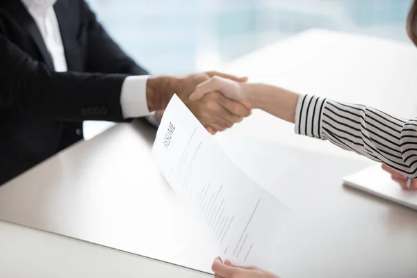 Close up of HR manager handshaking male applicant at interview — Stock Photo, Image