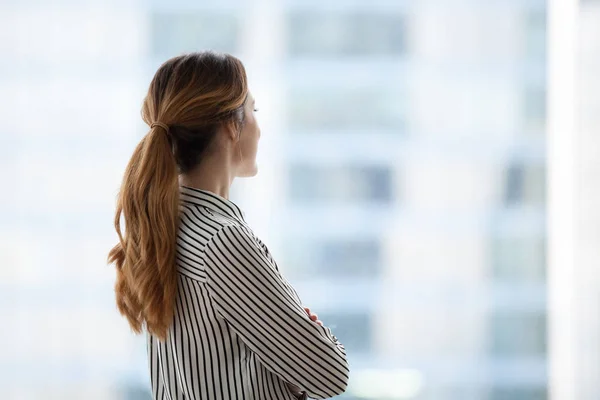 Millennial businesswoman looking in window dreaming of career pr. — стоковое фото