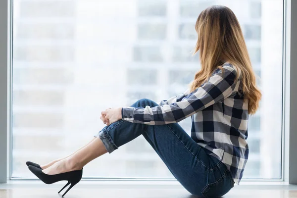 Thoughtful female sit on windowsill dreaming of future — Stock Photo, Image