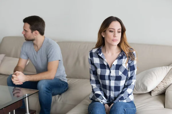 Pasangan yang marah duduk terpisah di sofa mengabaikan satu sama lain — Stok Foto