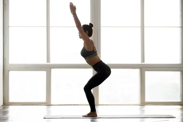 Joven deportista atractiva mujer practicando yoga, haciendo ejercicio de silla — Foto de Stock