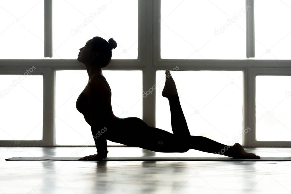 Young woman practicing yoga, doing upward facing dog exercise