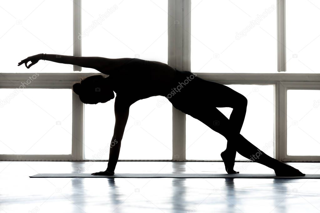 Young sporty attractive woman practicing yoga, doing  Wild Thing