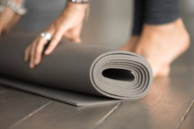 Kız unrolling gri fitness egzersiz mat için sınıf, yakın çekim