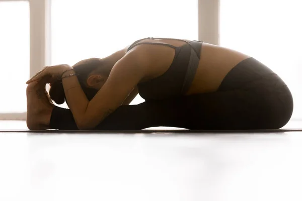 Young sporty attractive woman practicing yoga, paschimottanasana — Stock Photo, Image